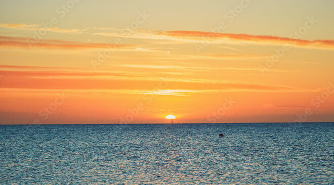 The sun sets over the ocean