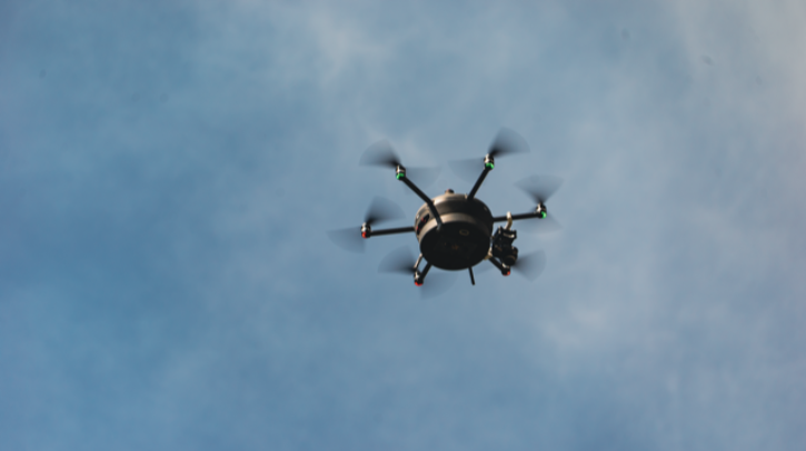 Meteomatics' autonomous Meteodrone flies through a blue sky with a few clouds.