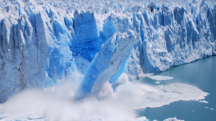 A glacier collapses into the sea.