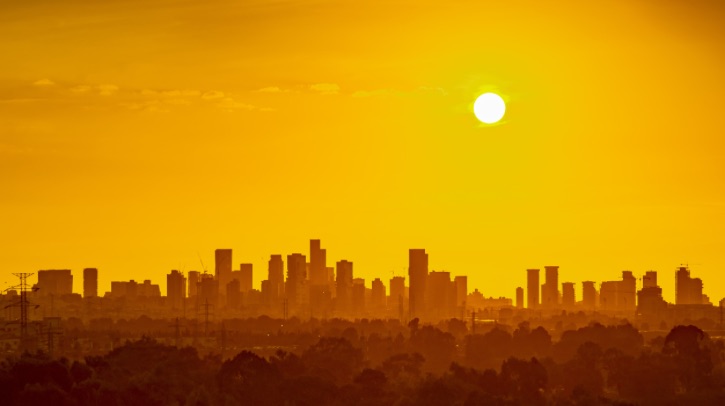The New York skyline is tinted orange with the sun in the background, as the city experiences a heat wave.