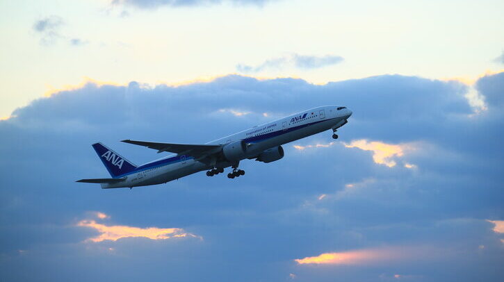A plane takes off with clouds in the background