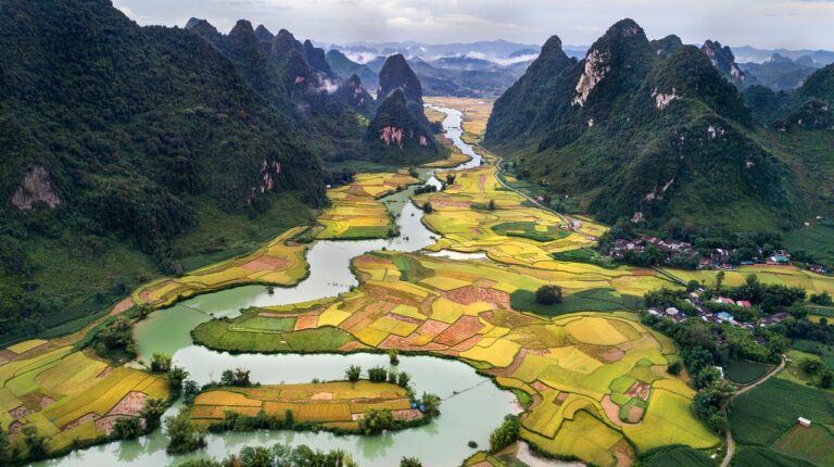 A river winds through a valley with sharp peaked ridges on either side