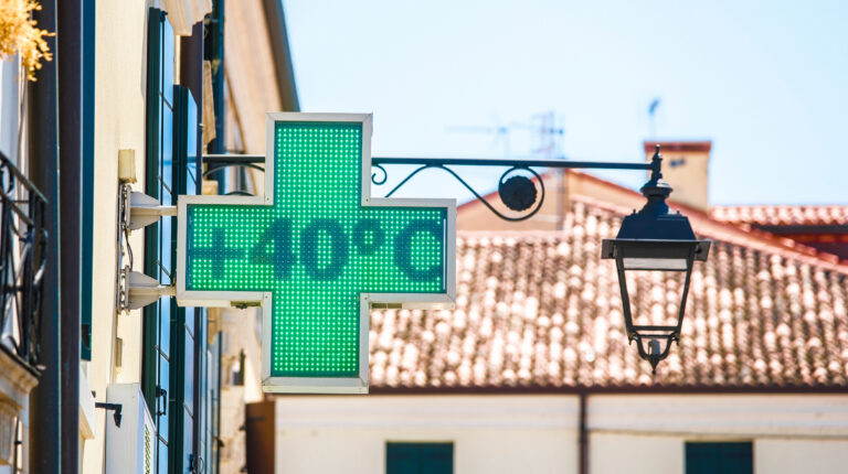 An electronic public display sign at a chemist on a street in Europe stating the temperature to be 40°C