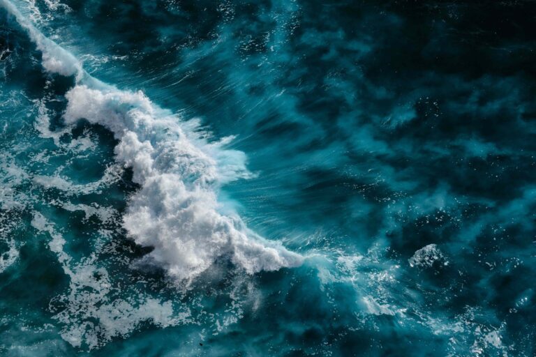 Aerial view to ocean waves. Blue water background.
