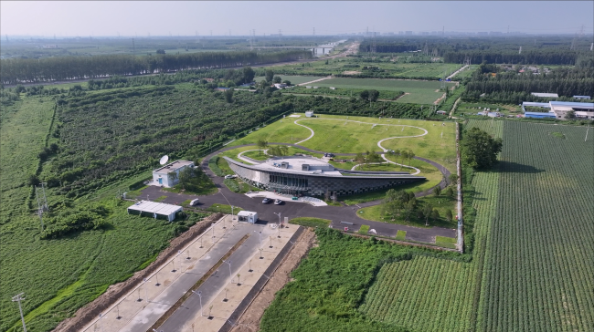 The Xiong’an national climate observatory in a rural area surrounded by green field.